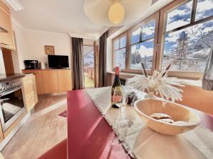 een keuken met een tafel en een fles wijn bij Hillside One - Ski-In Ski-Out Apartments am Arlberg in Warth am Arlberg
