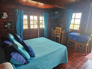 Un dormitorio con una cama con sábanas azules y una mesa. en La Maxada Luz Maria, en Cotillo