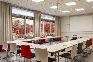 una sala conferenze con tavoli, sedie e una lavagna di Vienna House Easy by Wyndham Günzburg a Günzburg