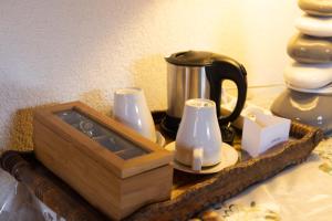 a wooden tray with a tea kettle and cups on a table at Chambres d'hôtes Les Rondins De La Fecht in Mittlach