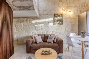 a living room with a couch and a table at Charming + Modern 1BR House in Historic Zebbug by 360 Estates in Żebbuġ