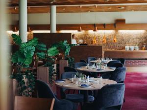 a dining room with tables and chairs and plants at Lærdal Hotel in Lærdalsøyri