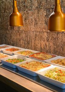 a buffet with many trays of food on a table at Lærdal Hotel in Lærdalsøyri