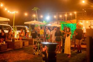 a group of people standing at an outdoor event at night at Innbox - Praia do Rosa in Praia do Rosa