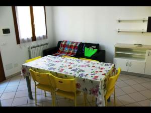 a kitchen with a table with yellow chairs around it at Adorable flat with attic in residence in Rosapineta