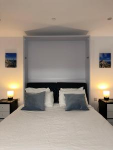 1 dormitorio con 1 cama blanca grande y 2 lámparas en E1 Apartment High Level Sea View en Gibraltar