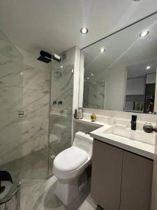 a bathroom with a toilet and a sink and a shower at Luxury apto doble altura Bogotá in Bogotá