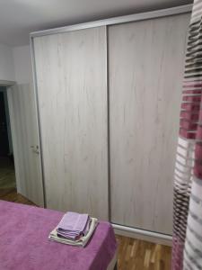 a room with a closet with purple sheets on a table at Apartman 022 in Smederevska Palanka