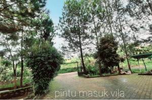 a park with trees and a walkway with a gate at Villadamailembang in Padasul