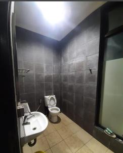 a bathroom with a white toilet and a sink at Villadamailembang in Padasul