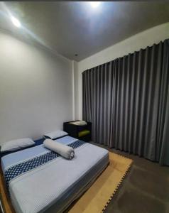 a bedroom with a bed and a large window at Villadamailembang in Padasul