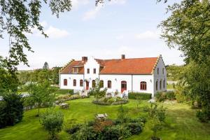 ein großes weißes Haus mit rotem Dach in der Unterkunft Vita Huset på Österlen in Gärsnäs