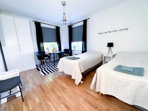カールスタードにあるStrandgården Karlstadのベッドルーム1室(ベッド2台、テーブル、椅子付)