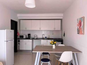 uma cozinha com uma mesa de madeira e armários brancos em Cozy 2 Bedroom in Olhão em Quelfes