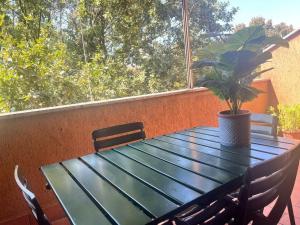 a green table with a potted plant on a balcony at Grace's House - Milan & Rho Fiera in Vittuone
