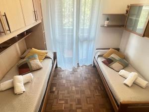 2 camas en una habitación pequeña con ventana en Grace's House - Milan & Rho Fiera, en Vittuone