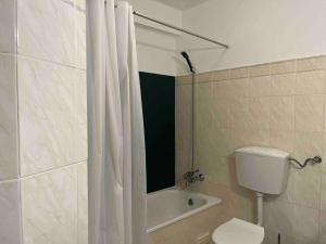 a bathroom with a toilet and a shower curtain at Cozy 2 Bedroom in Olhão in Quelfes
