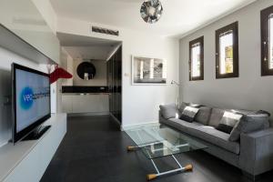 - un salon avec un canapé et une télévision dans l'établissement Veoapartment Relator Terraza, à Séville