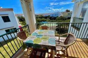 einen Tisch und Stühle auf dem Balkon in der Unterkunft BoschApartamento de 2 dormitorios y con piscina in Ciutadella