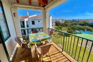 porche con mesa y sillas en el balcón en BoschApartamento de 2 dormitorios y con piscina en Ciutadella