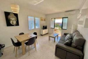 een woonkamer met een bank en een tafel bij BoschApartamento de 2 dormitorios y con piscina in Ciutadella