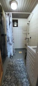 baño con cortina de ducha y suelo de baldosa. en Kuosto ja Luppo, en Äkäslompolo