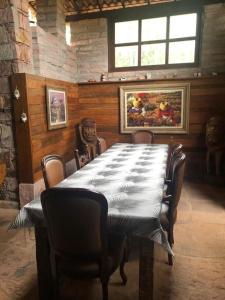 une salle à manger avec une grande table et des chaises dans l'établissement Pousada Casa Fraternità, viva momentos de tranquilidade em contato com a natureza., à Andaraí