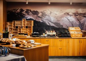 a restaurant with a mural of mountains on the wall at Aktiv & Genusshotel Lodenwirt in Vandoies +53 photos