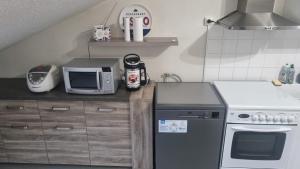 een kleine keuken met een fornuis en een magnetron bij Appartement T3 60m2 calme in Morez