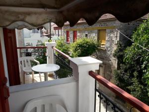 a balcony with a white table and a chair at Dimi's studio in Skala Kallonis