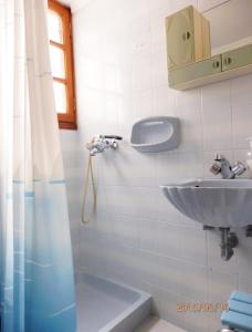 een badkamer met een wastafel en een douche bij Dimi's studio in Skala Kallonis