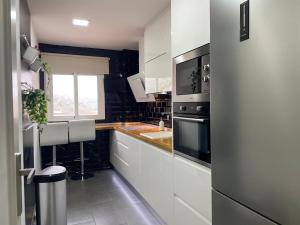 a white kitchen with a sink and a microwave at Torre del reloj - Parking gratis in Cazorla