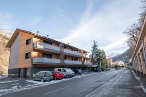 a building on the side of a street with parked cars at La Niche 2 in Brides-les-Bains