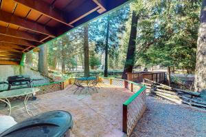 un patio al aire libre con mesa, sillas y árboles en Wallowa Lake Inn, Whole Home, en Joseph