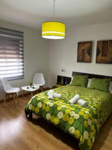 1 dormitorio con 1 cama con colcha verde en Casa Ubedí en pleno casco histórico en Úbeda
