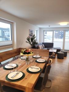 ein Wohnzimmer mit einem Holztisch mit Tellern und Weingläsern in der Unterkunft Winterberg Appartement 21129 in Winterberg