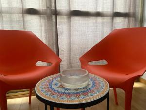 two red chairs with a bowl on a table between them at Casa Lalli in Lecce
