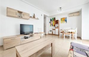 uma sala de estar com uma televisão de ecrã plano e uma mesa em Stunning Apartment In Oropesa With House Sea View em Oropesa del Mar