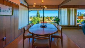 uma sala de jantar com mesa e cadeiras e uma grande janela em PA Horizon Hillside em Port Angeles