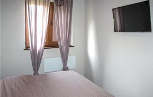 een slaapkamer met een bed en een raam met gordijnen bij Pet Friendly Home In Korenica With Kitchen in Korenica
