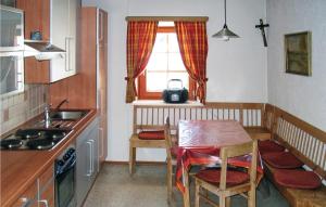 kuchnia ze stołem, małym stołem i oknem w obiekcie Ferienhaus In Maria Luggau w mieście Maria Luggau