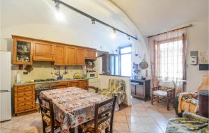 Awesome Home In Camino Monferrato With Kitchen في Camino: مطبخ مع طاولة وغرفة طعام