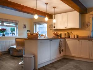 a kitchen with white cabinets and a counter at The Greenwoods in Barrowford