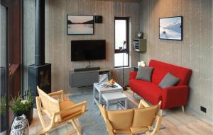 a living room with a red couch and a tv at Nice Apartment In Straumgjerde With Wifi And 2 Bedrooms 