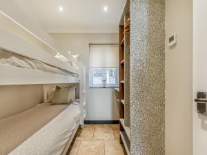 a bedroom with a bunk bed and a window at Milkwood in Pendine