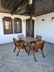 Une table et des chaises en bois sont disponibles sur la terrasse. dans l'établissement Vila Toplika, à Kara Agach