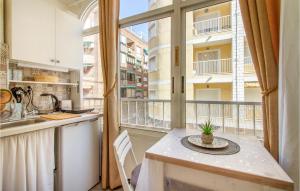 a kitchen with a table and a large window at Gorgeous Apartment In Torrevieja With Kitchen in Torrevieja