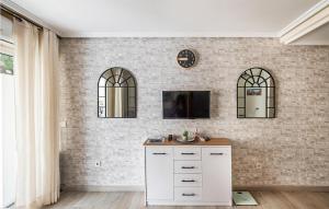 a kitchen with white cabinets and a brick wall at Gorgeous Apartment In Torrevieja With Kitchen in Torrevieja