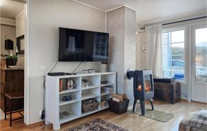 a living room with a flat screen tv on a wall at Amazing Apartment In Hemnskjela With Kitchen 