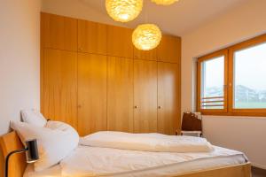 a bedroom with a bed with wooden panels and two lights at Edelweiss Ferienwohnung, Panoramablick in Flims